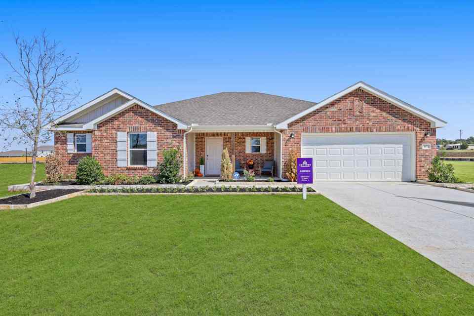 A brick house with a lawn.