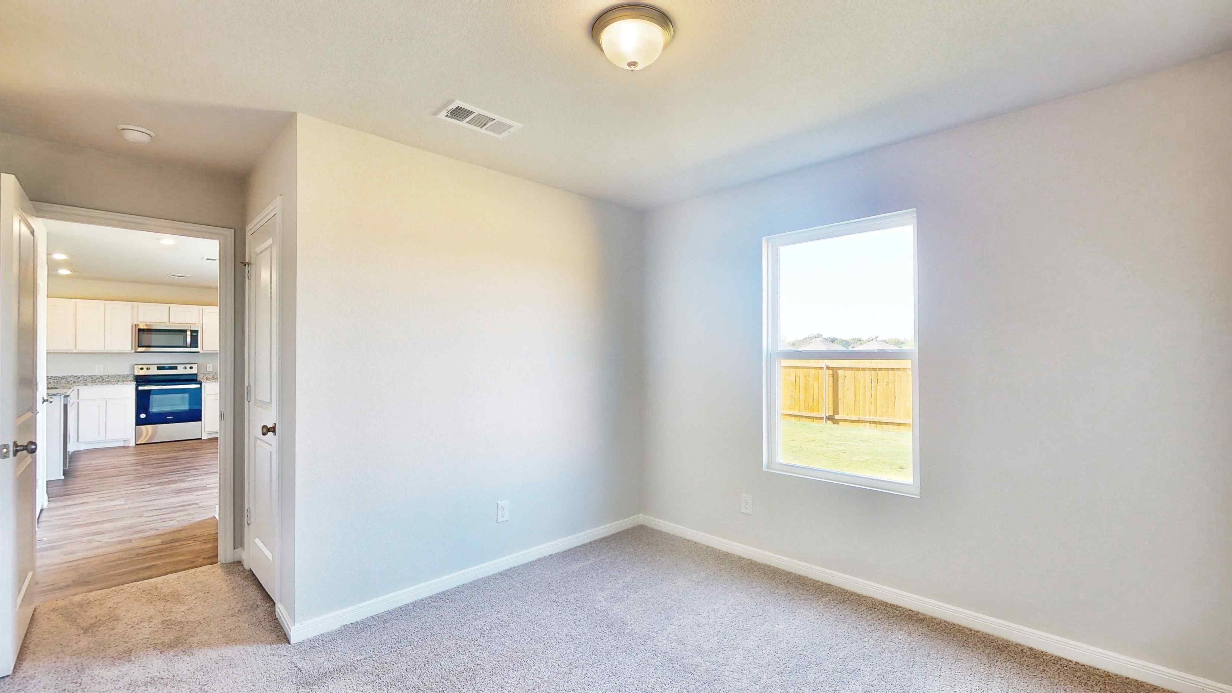 A room with a window and a kitchen.