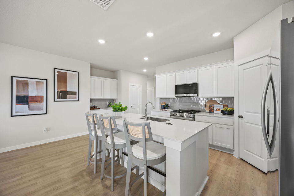 A kitchen with white cabinets.
