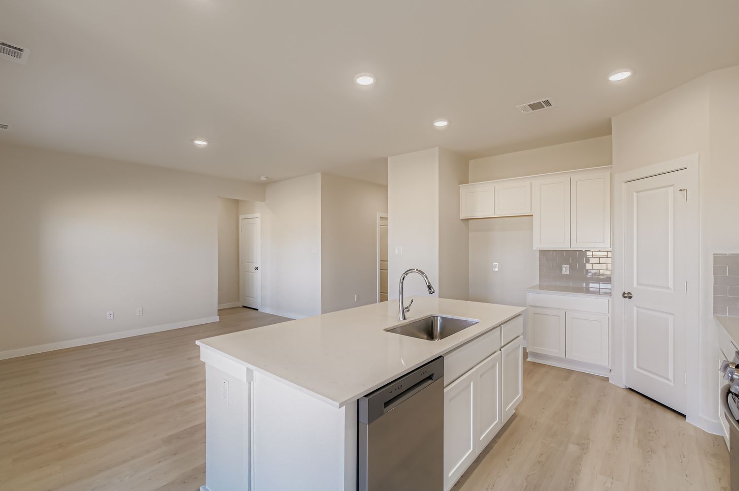 A kitchen with white cabinets.