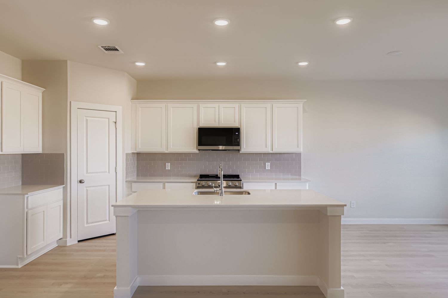 A kitchen with white cabinets.