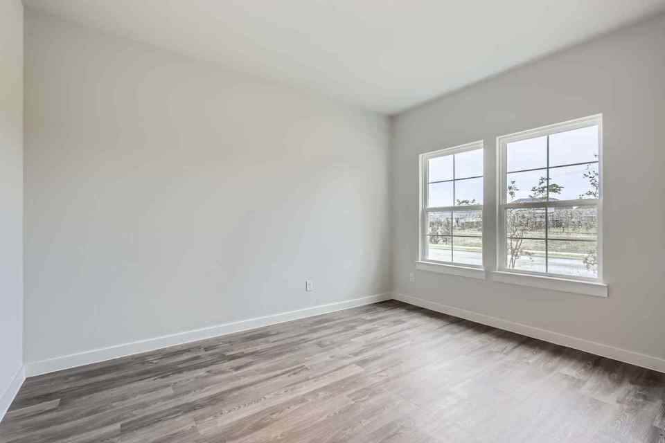 A room with a wood floor and windows.