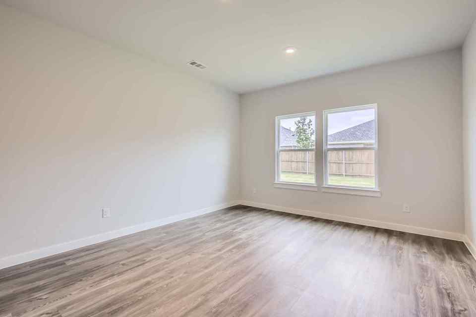 A room with a wood floor and a window.