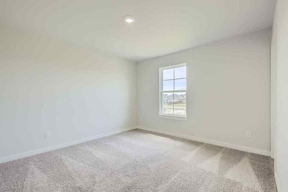 A room with a window and carpet.