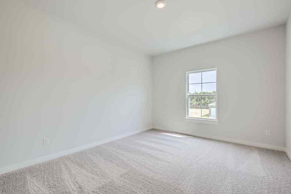 A room with a window and a carpet.