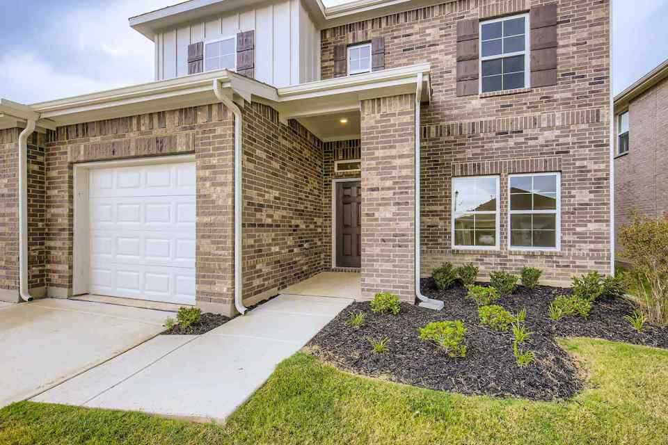 A brick house with a driveway.