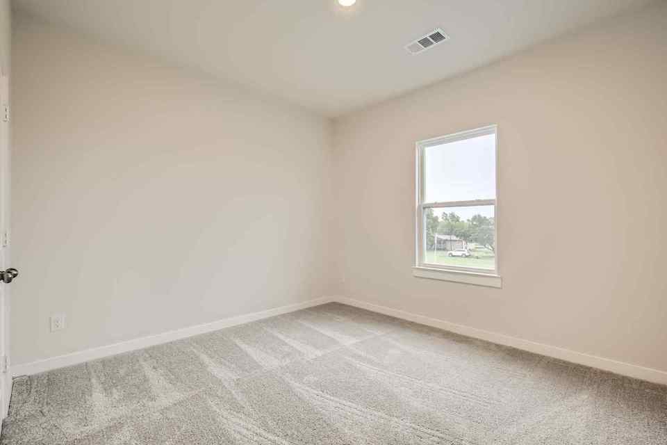 A room with a window and a carpet.