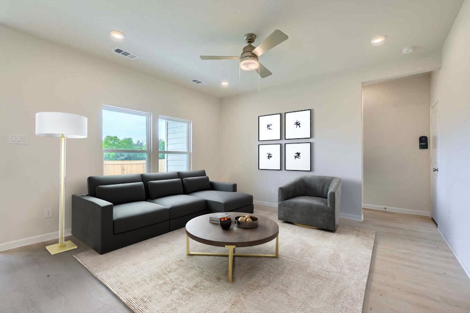 A living room with a black couch and a coffee table.