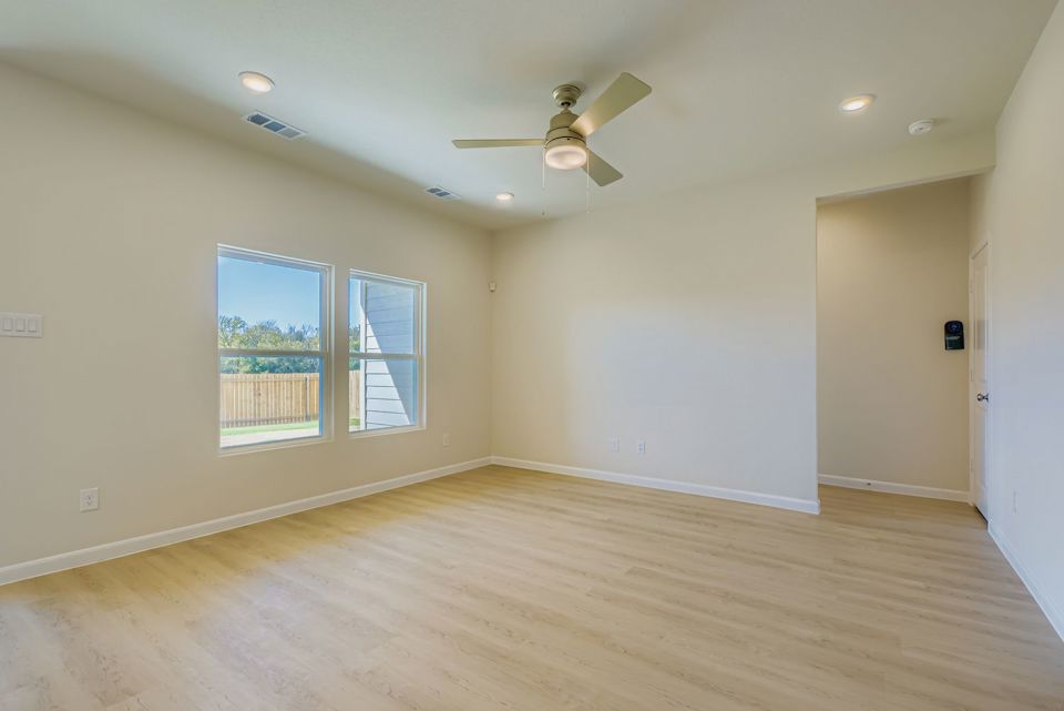 A room with a wood floor and a ceiling fan.