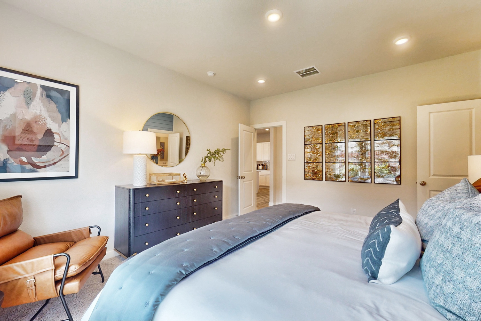 A bedroom with a bed and a chair.