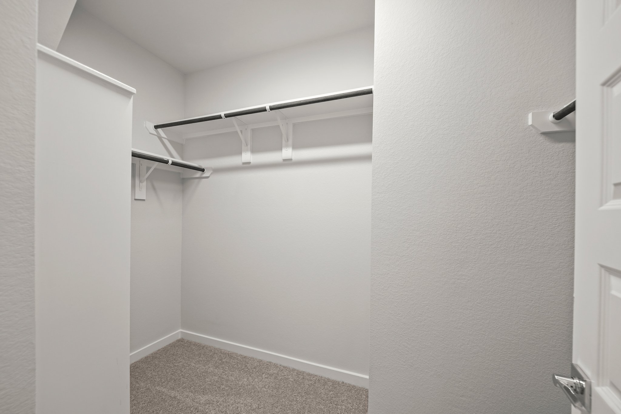 A white hallway with a metal railing.