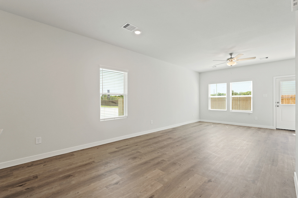 A room with a wood floor and a ceiling fan.