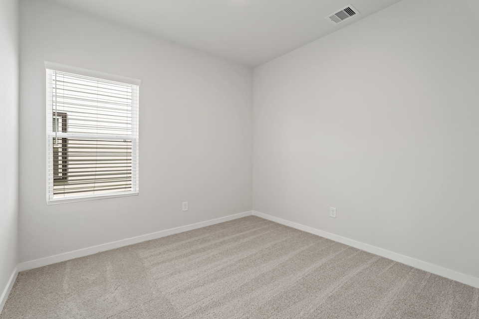 A room with a window and a carpet.