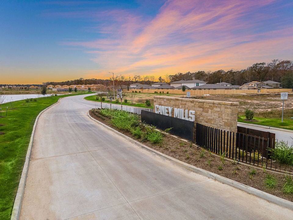 A road with a fence and grass on the side.