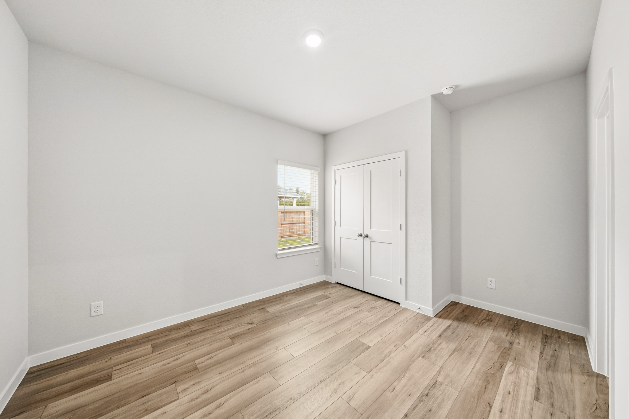 A room with white walls and a wood floor.