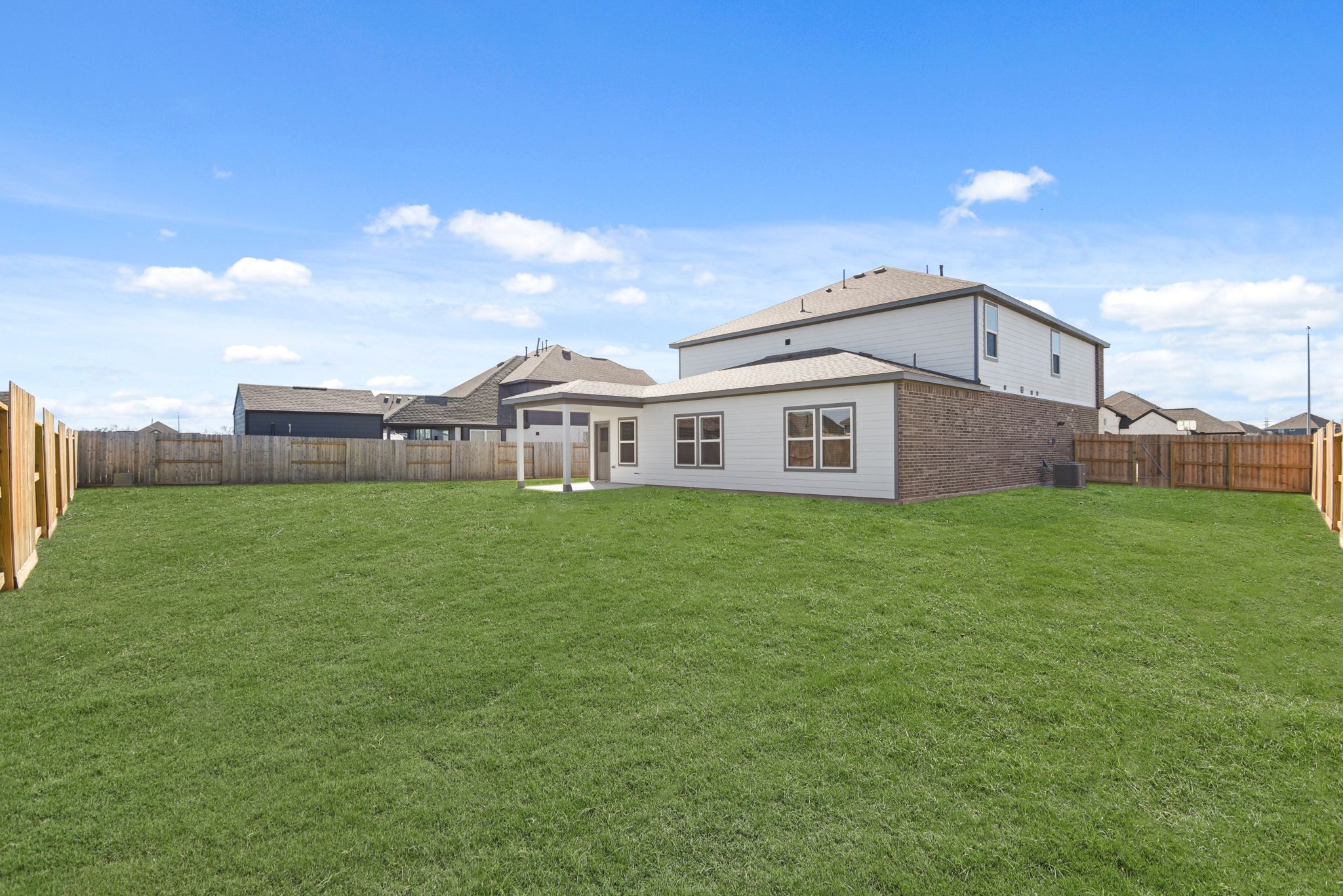 A large green lawn in front of a house.