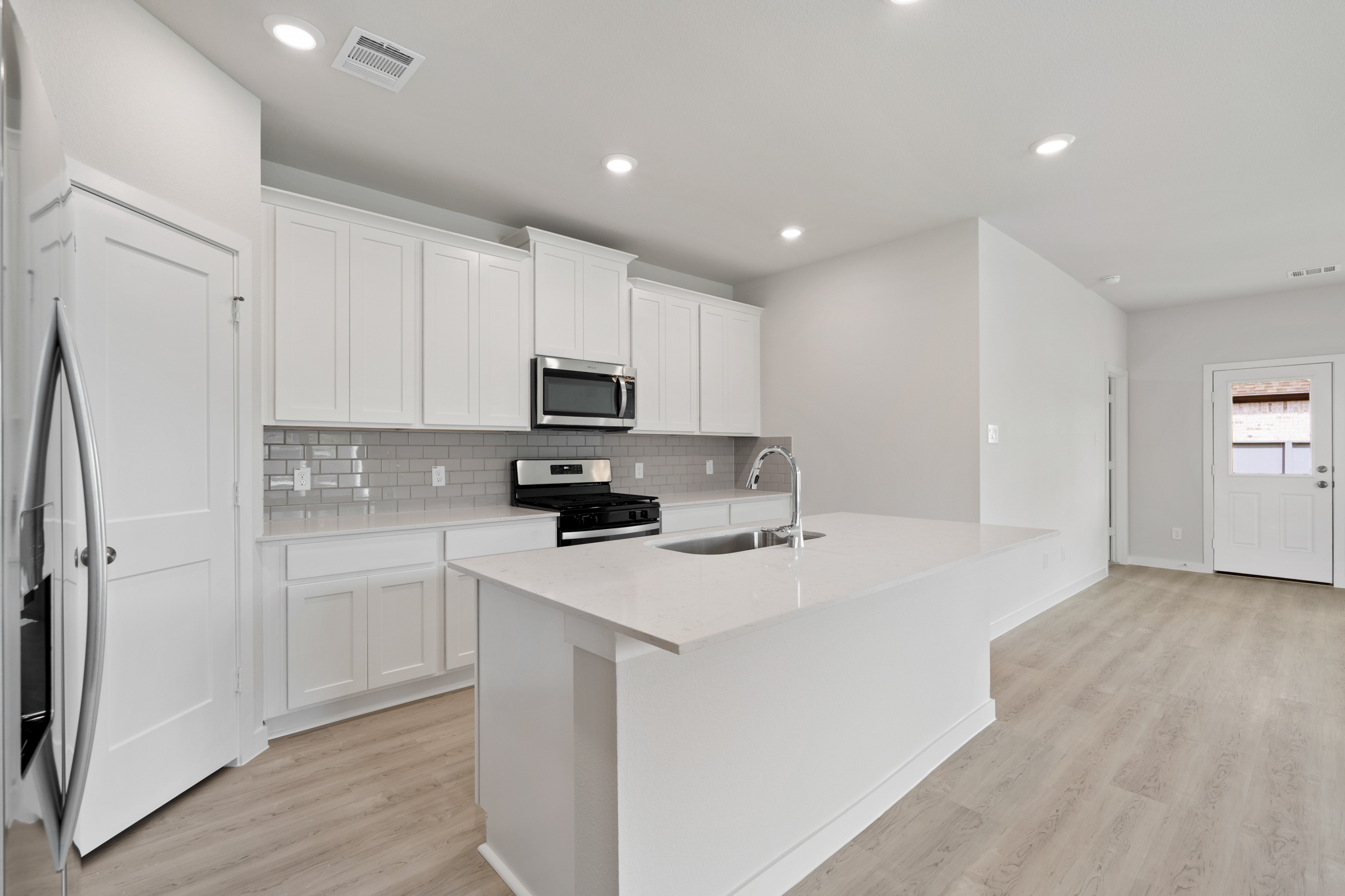 A kitchen with white cabinets.