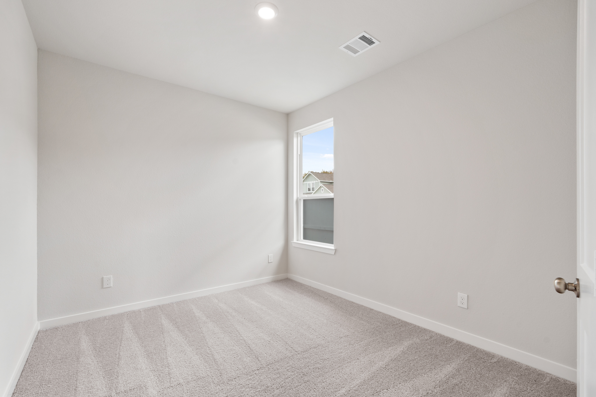 A room with a window and a carpet.