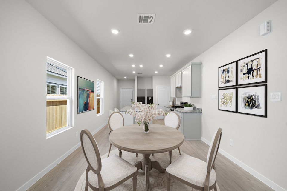 A dining room with a table and chairs.
