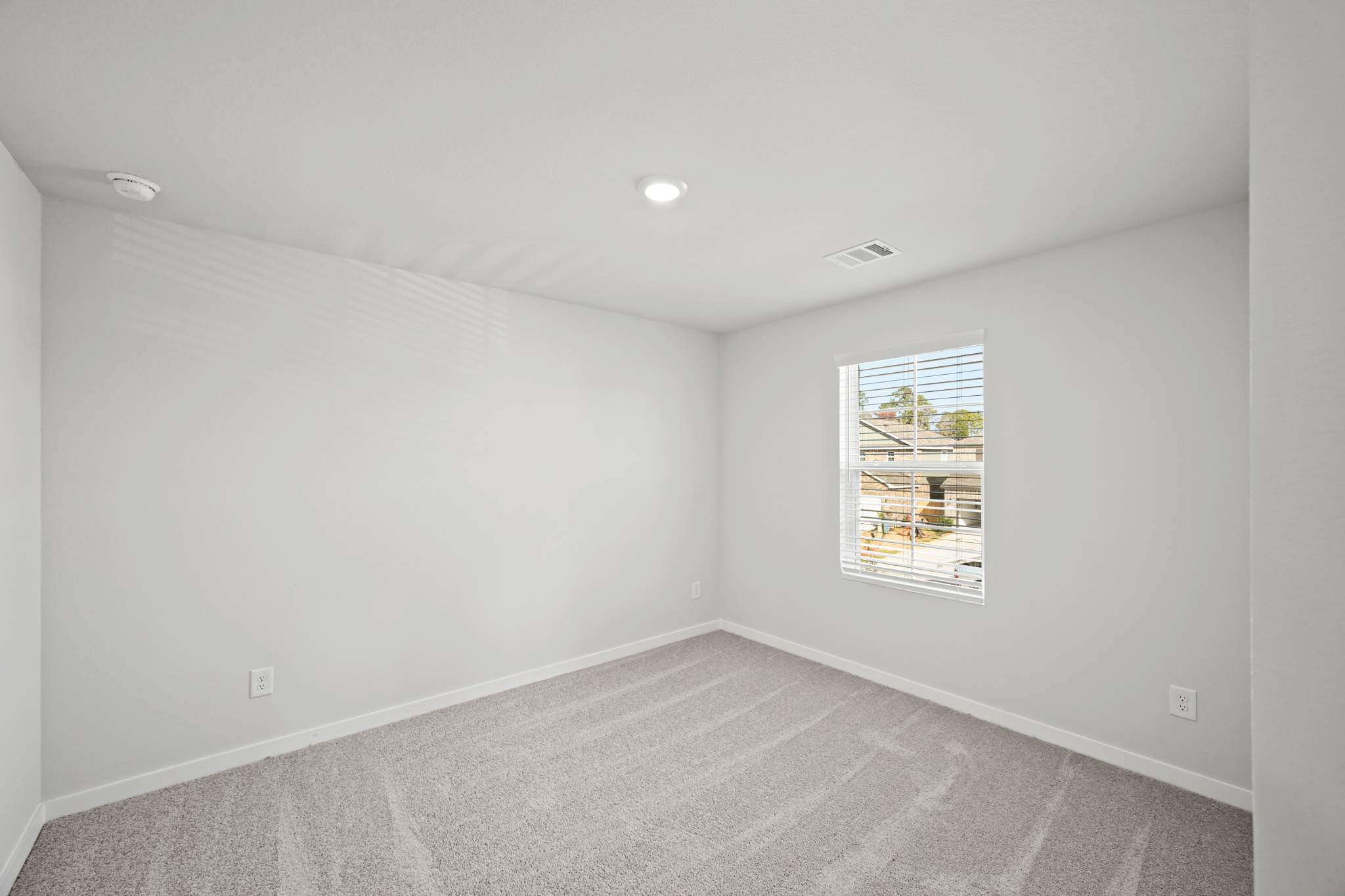 A room with a window and a carpet.