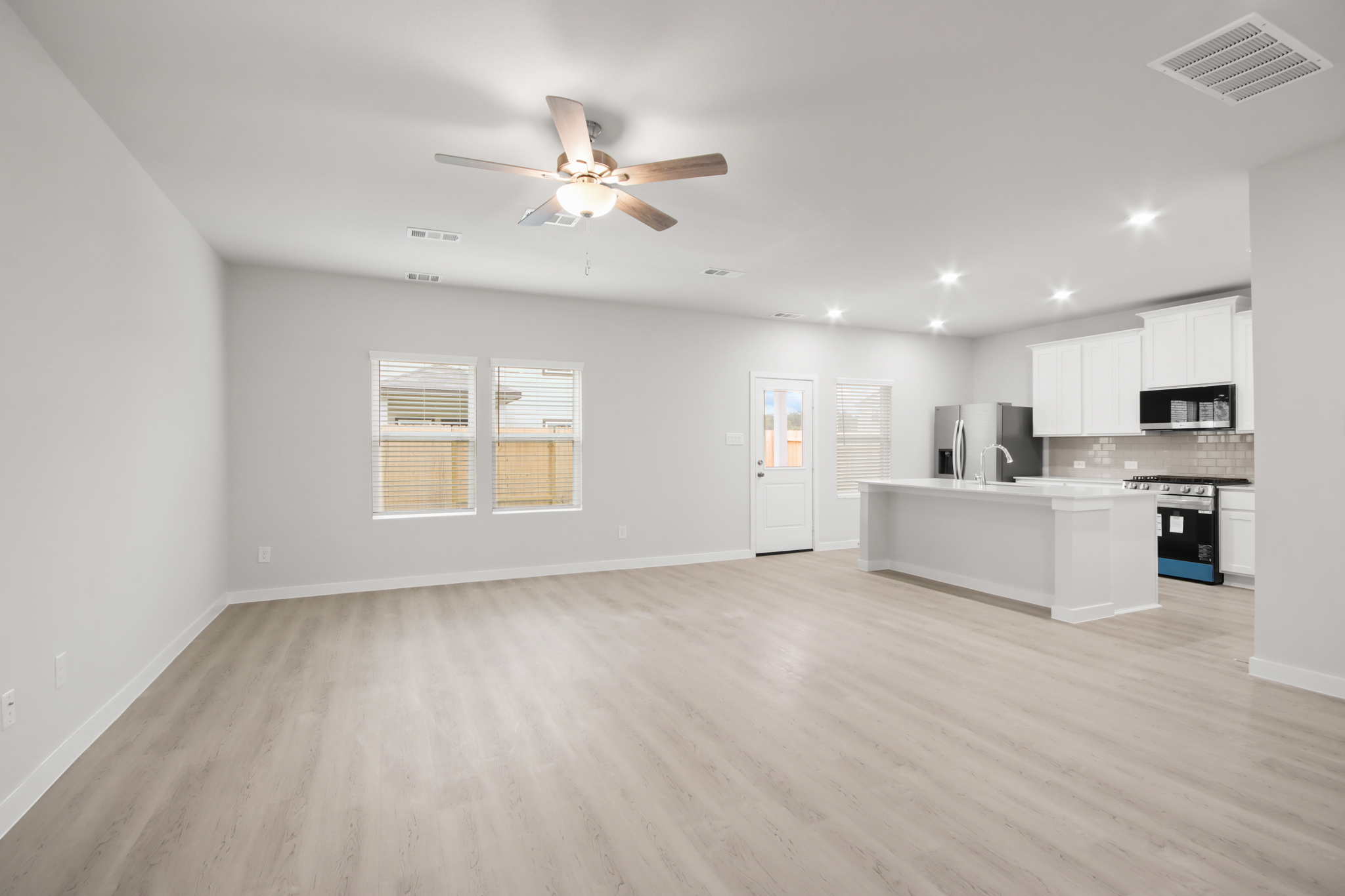A large kitchen with a wood floor.