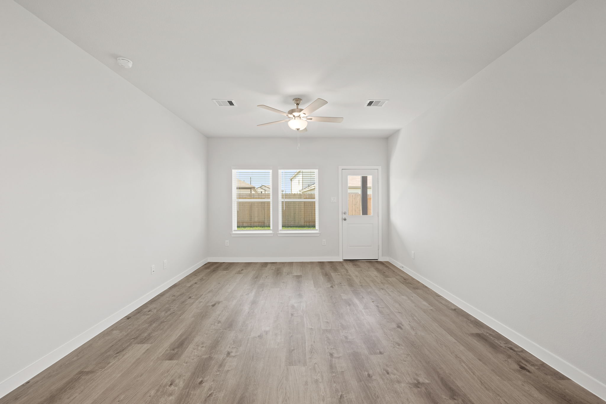 A room with a wood floor and a ceiling fan.