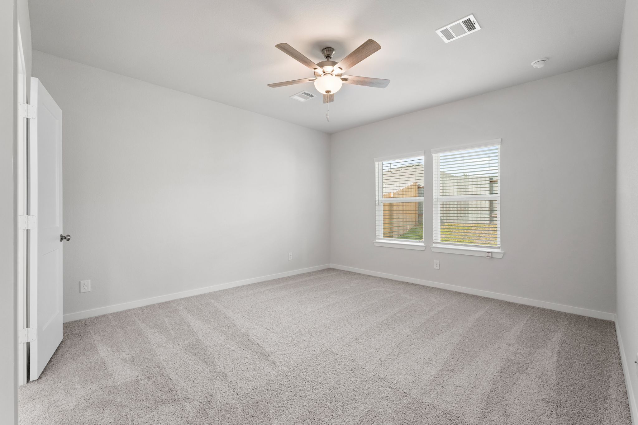 A room with a ceiling fan and a window.