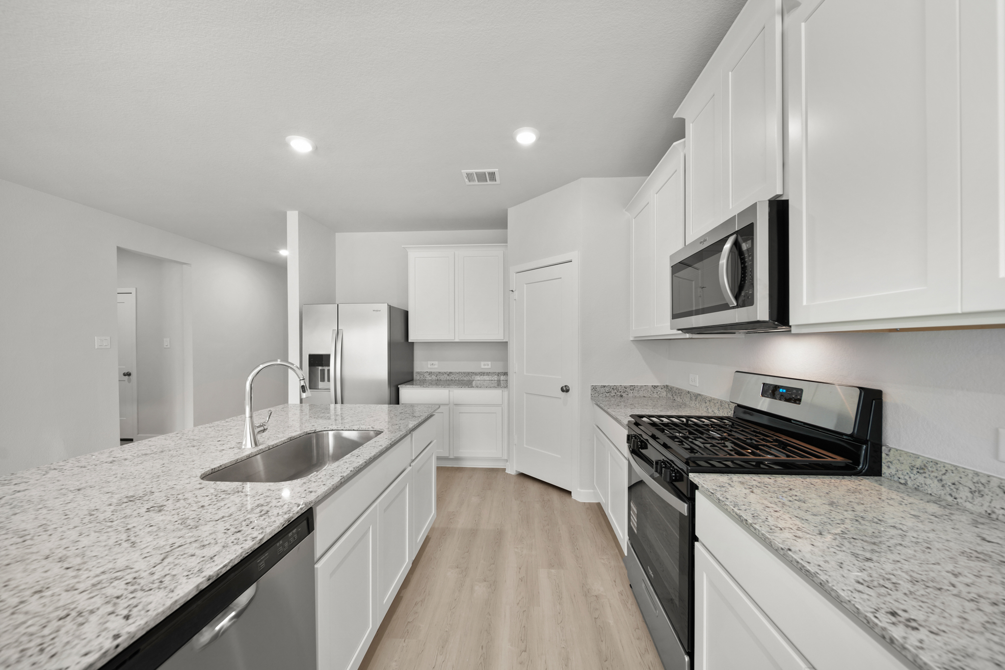 A kitchen with white cabinets.