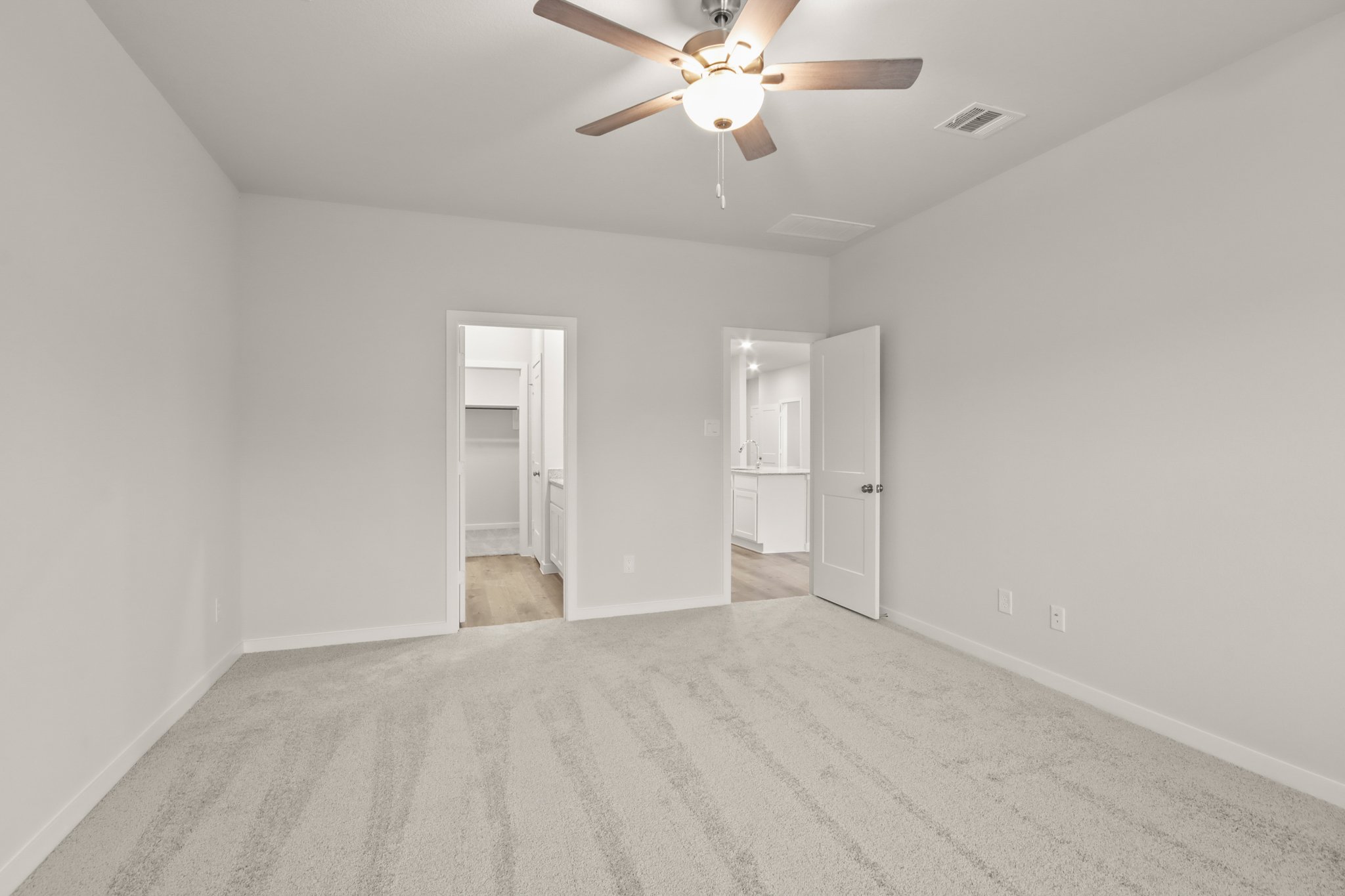 A room with a ceiling fan and a door.