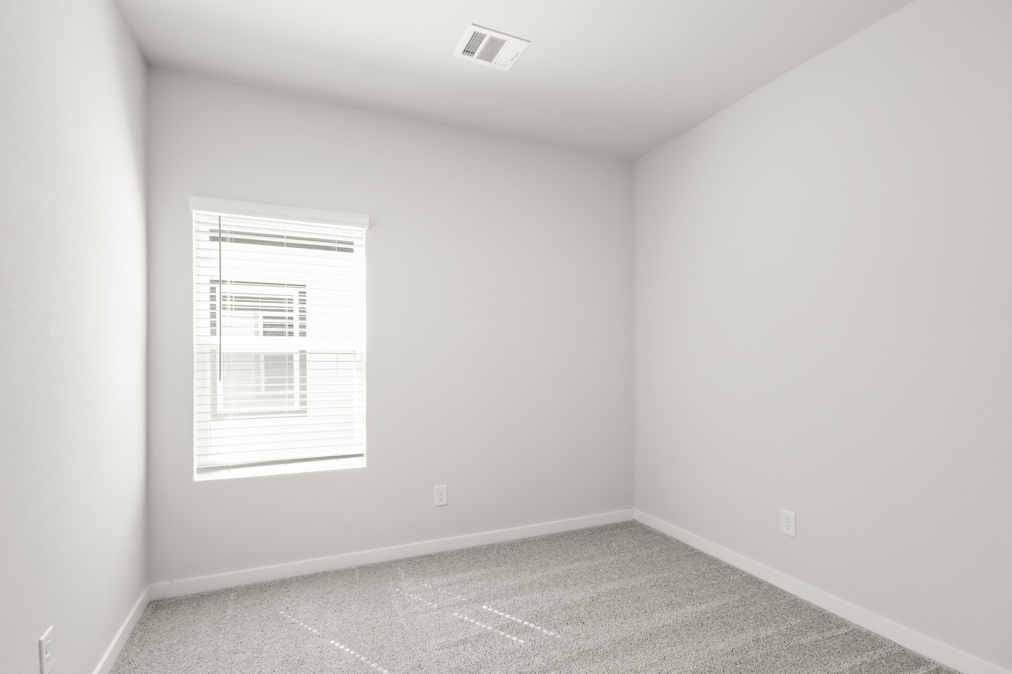 A room with a white wall and a window.
