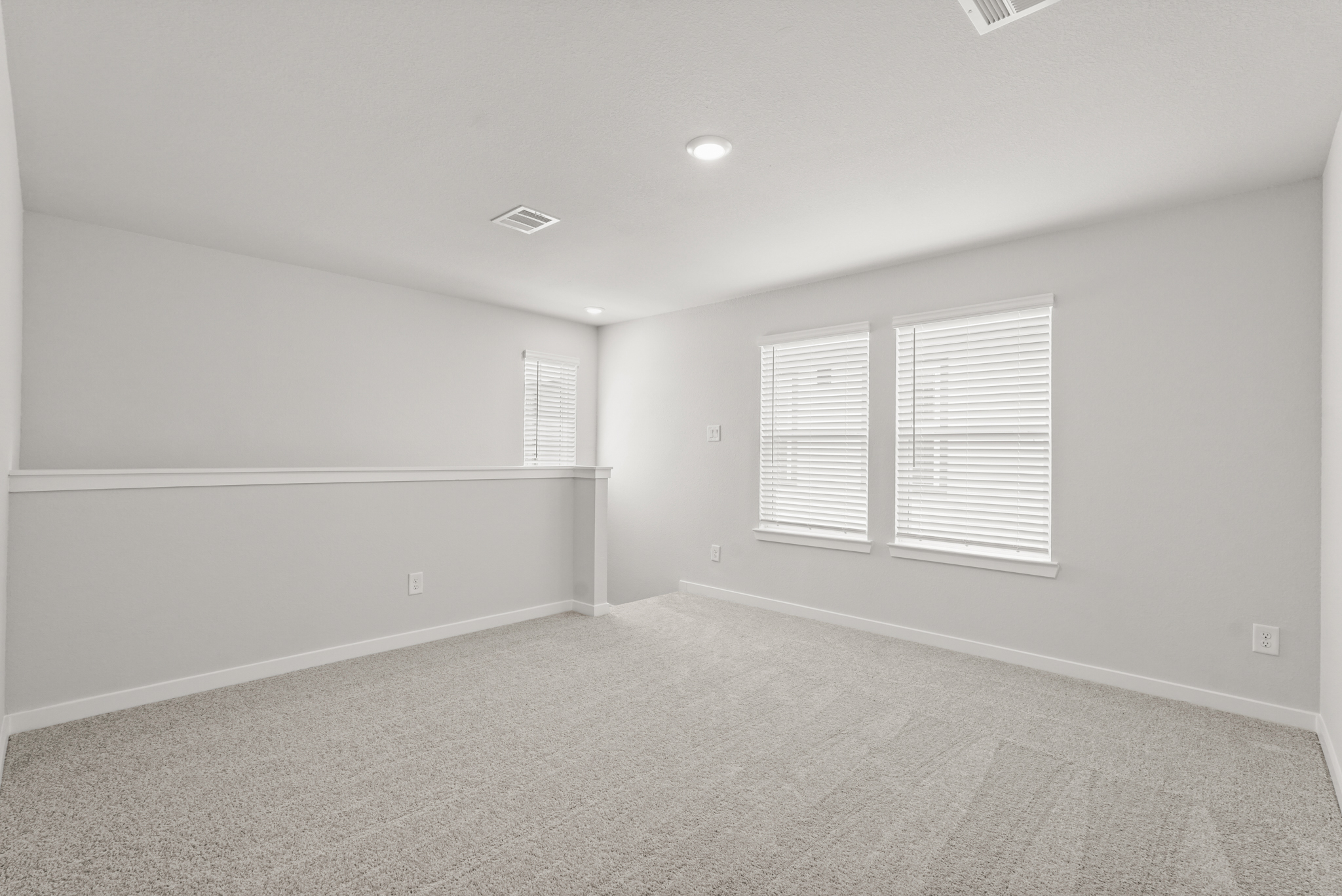 A room with a carpet and windows.
