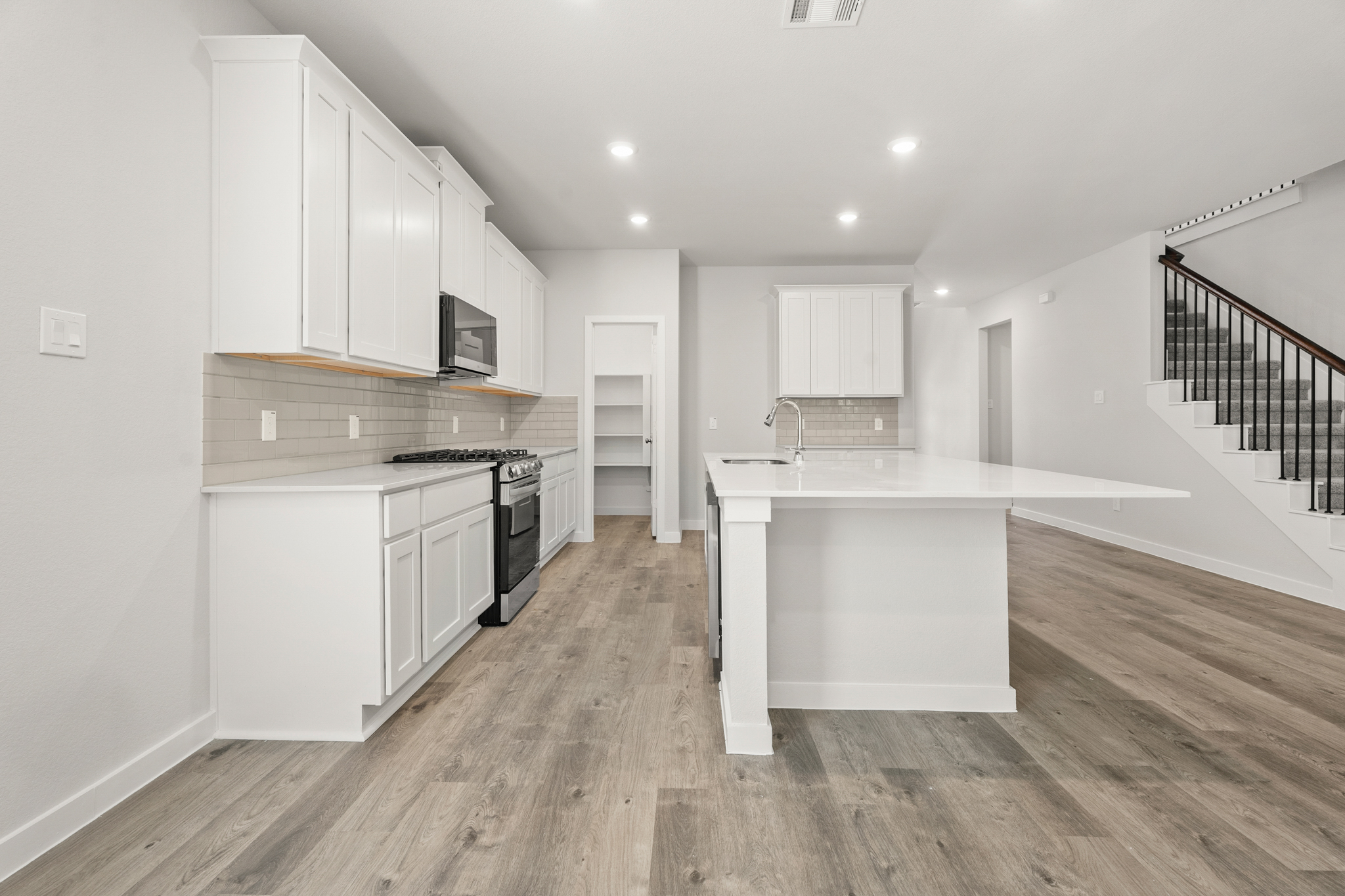 A kitchen with white cabinets.