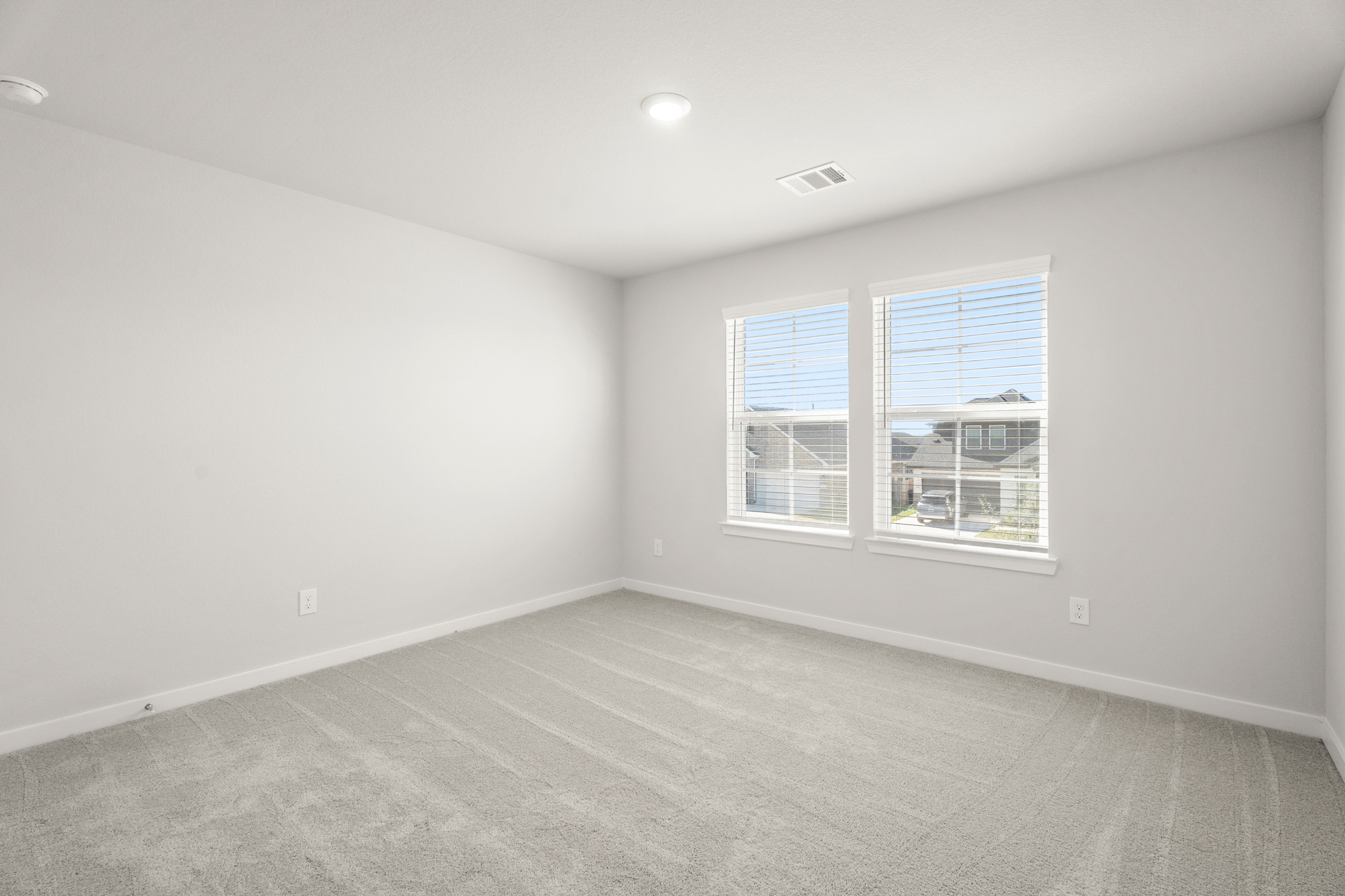 A room with a window and a white wall.