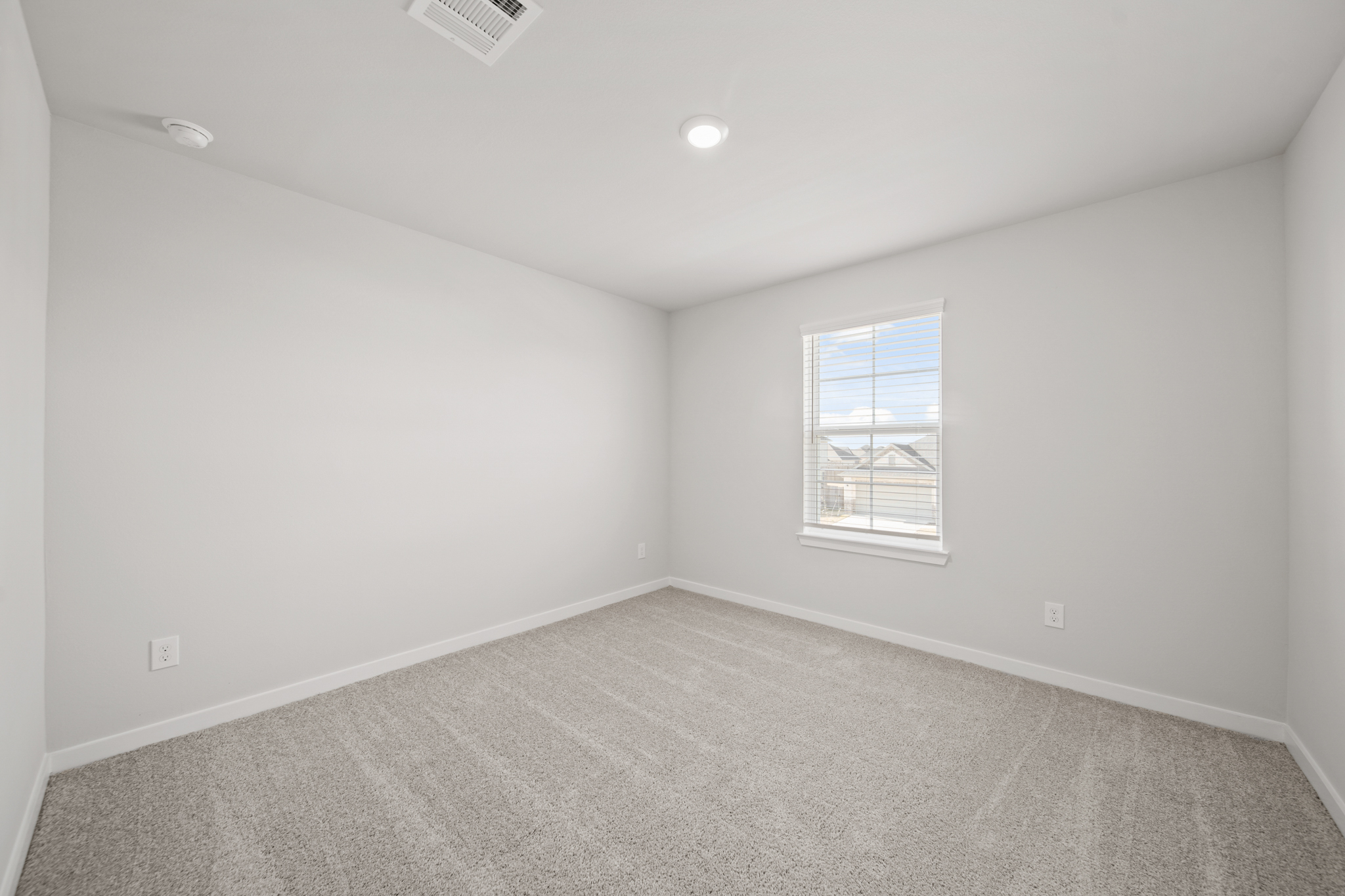 A room with a window and a carpet.