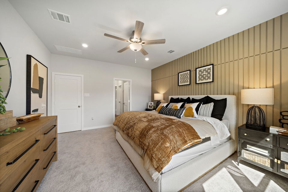 A bedroom with a bed and a fan.