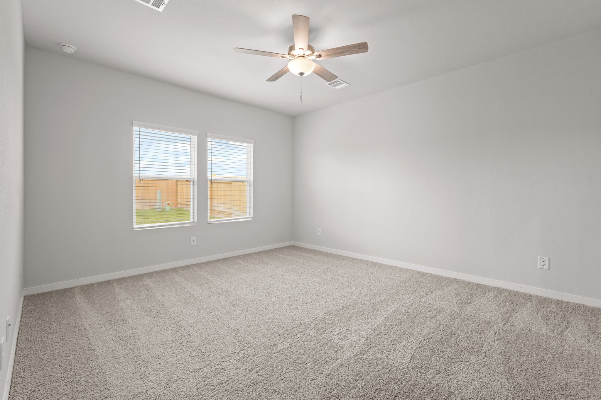 A room with a ceiling fan and a window.