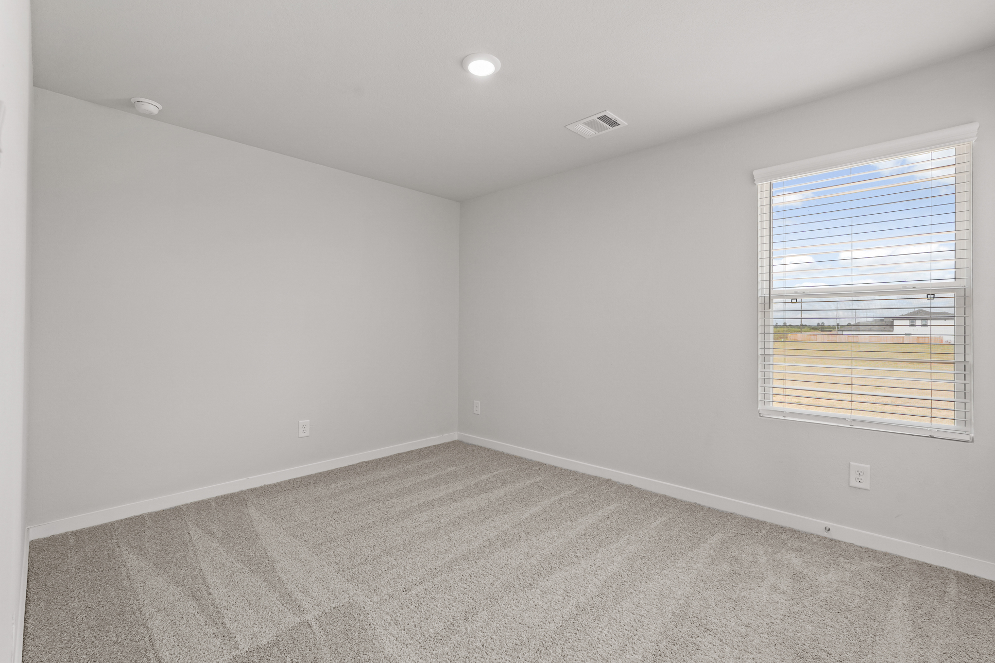 A room with a window and a carpet.