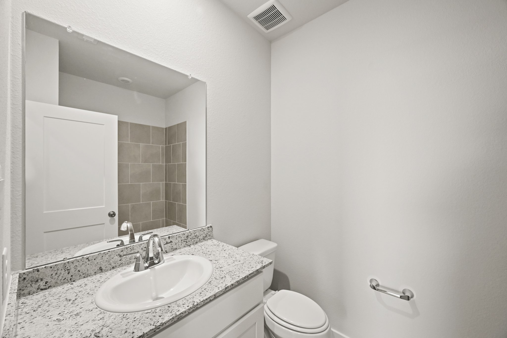 A bathroom with a large mirror.