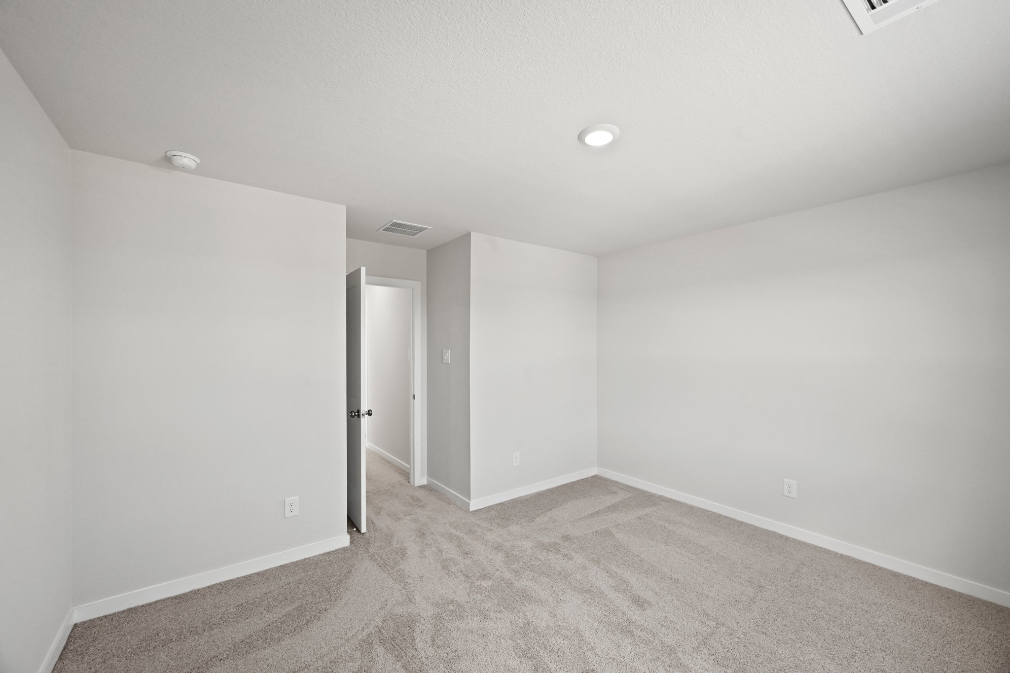 A room with a carpet and a door.