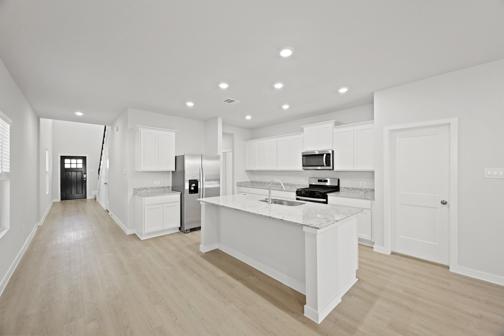 A kitchen with white cabinets.