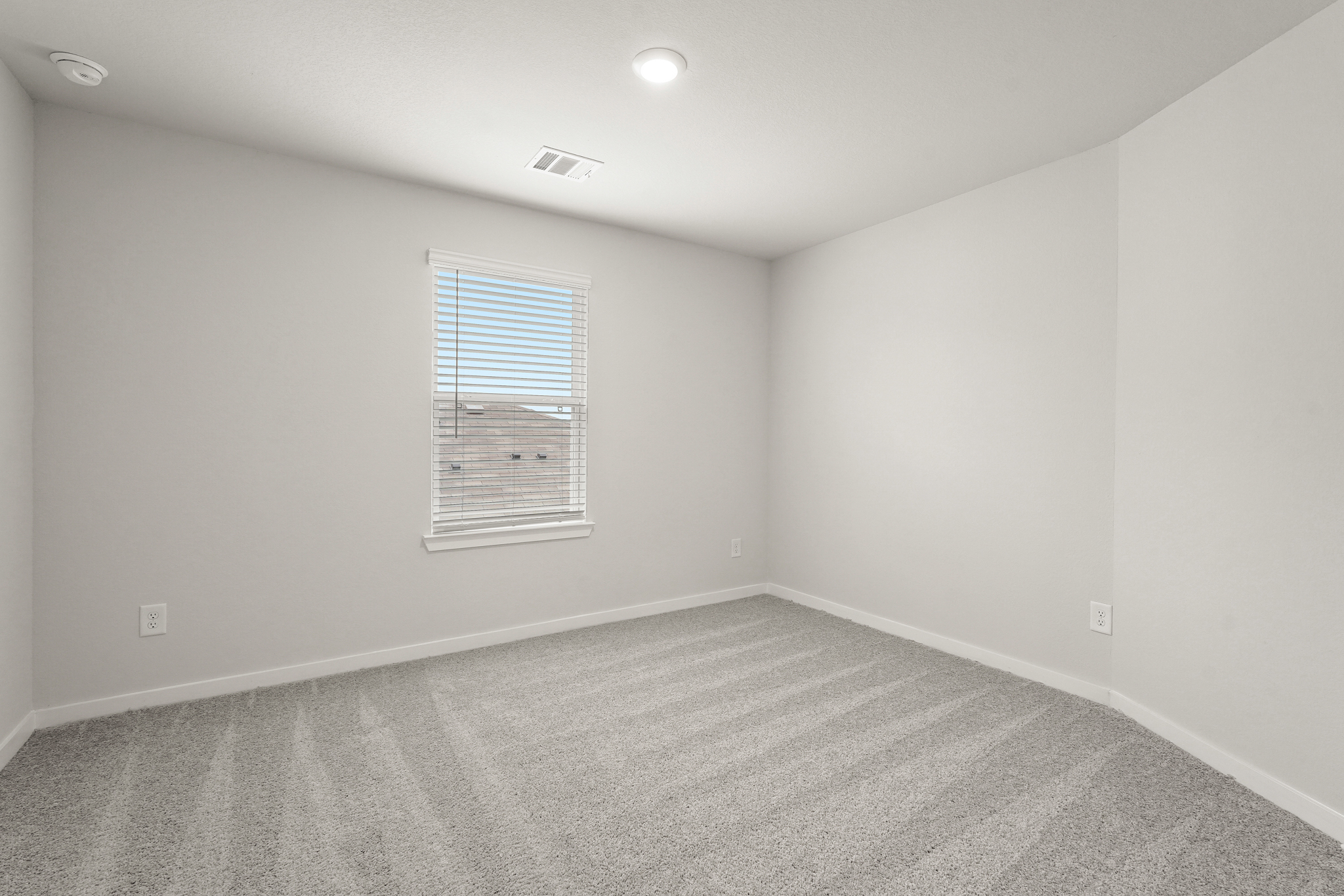 A room with a window and a carpet.