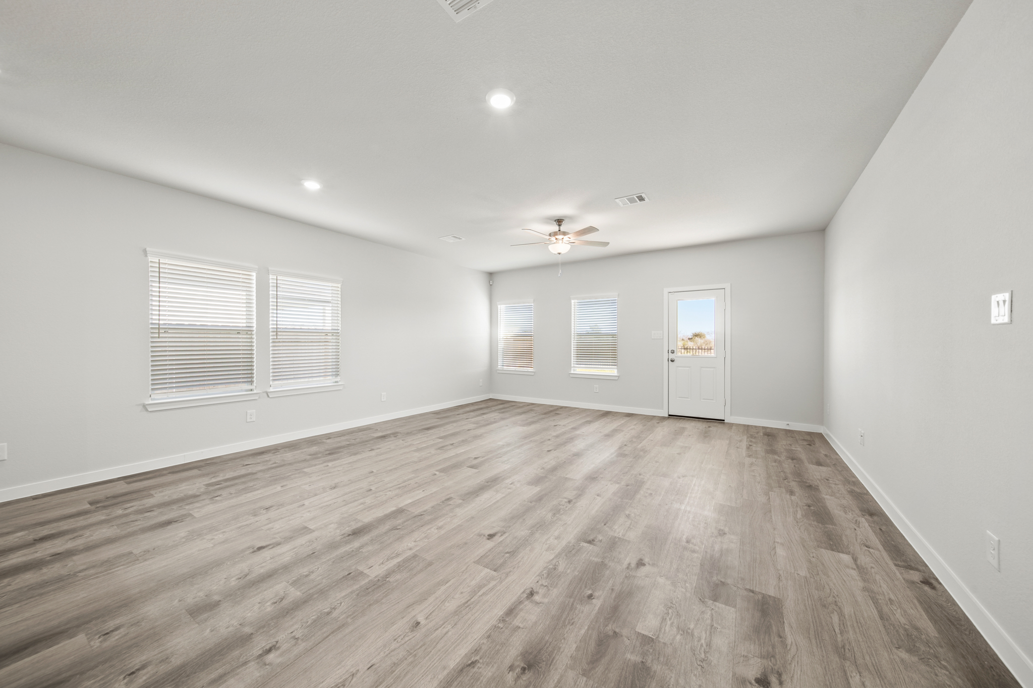 A room with a wood floor and a ceiling fan.