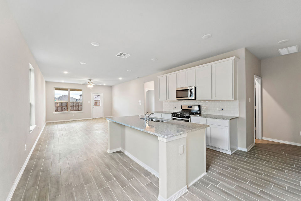 A kitchen with white cabinets.