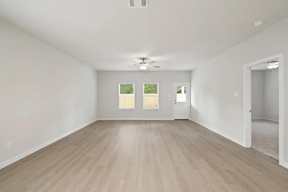 A room with a wood floor and a ceiling fan.