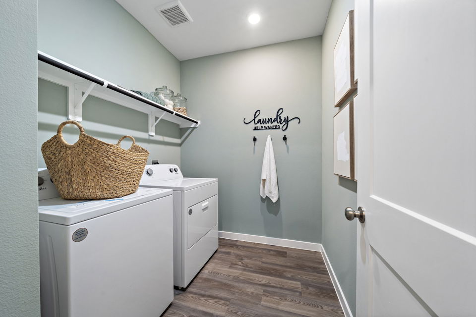 A laundry room with a basket on the wall.