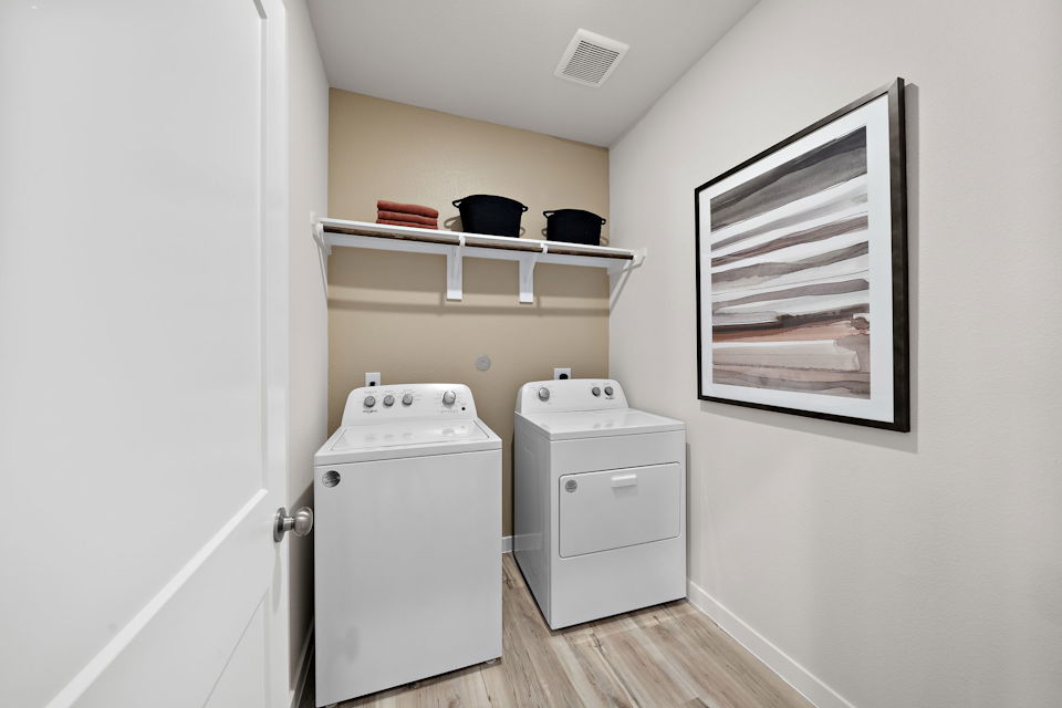 A room with a shelf and a white cabinet with a white door.