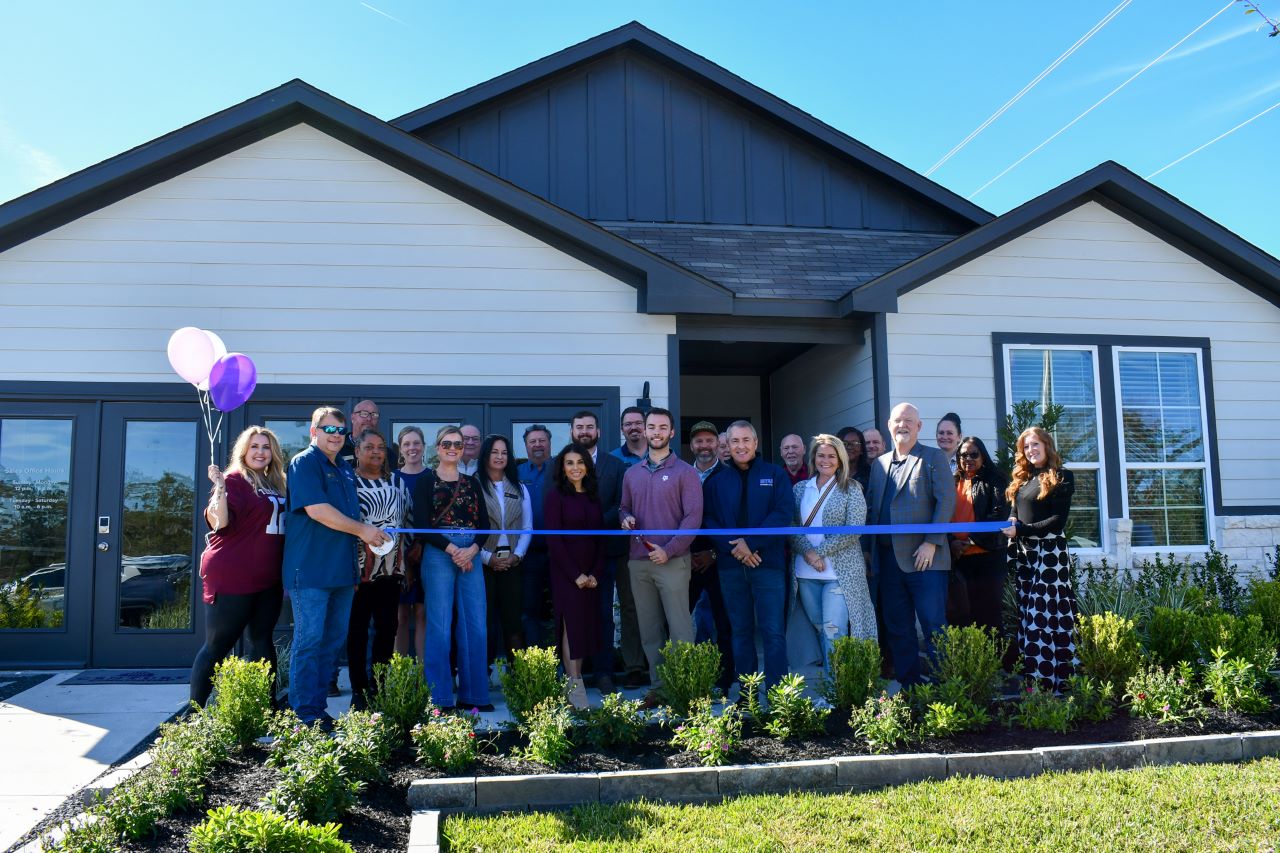 A group of people posing for a photo in front of a house.