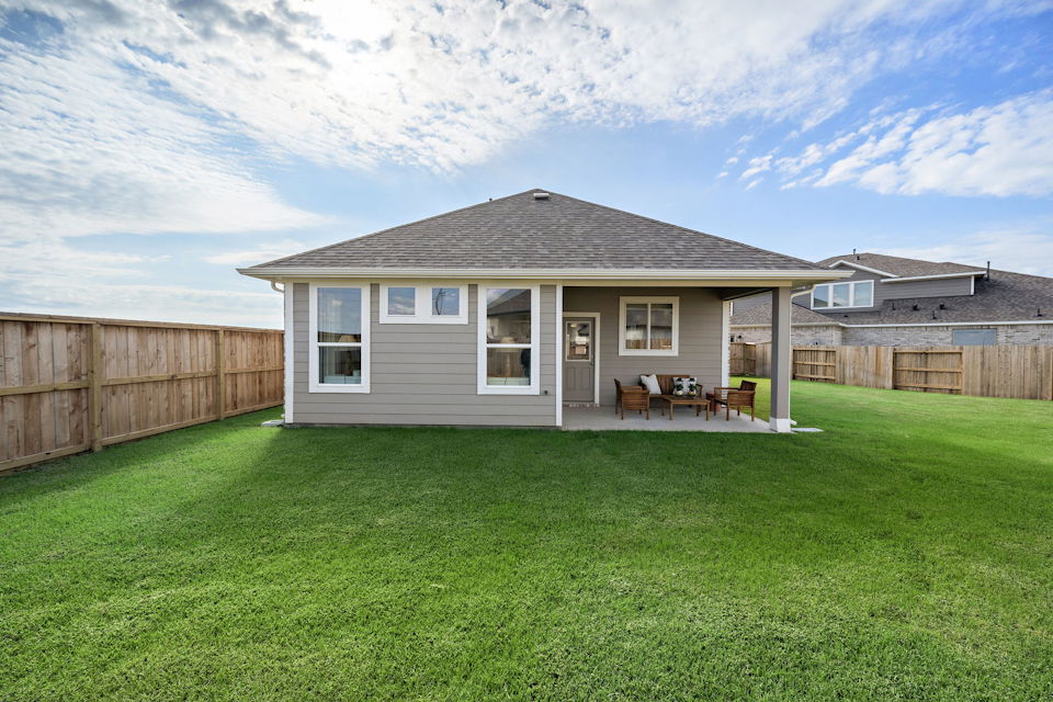 A house with a lawn and chairs.