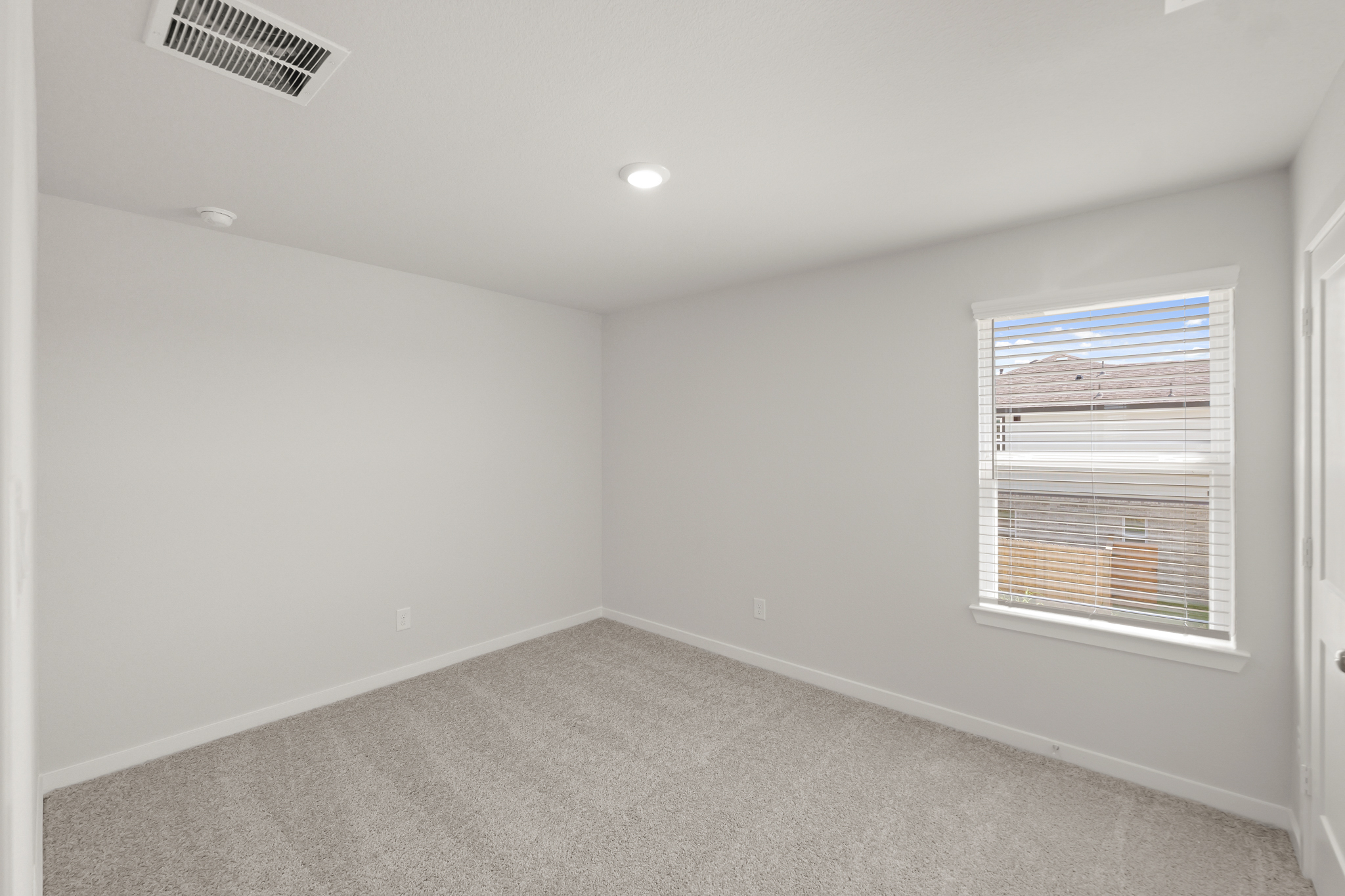 A room with a window and a carpet.