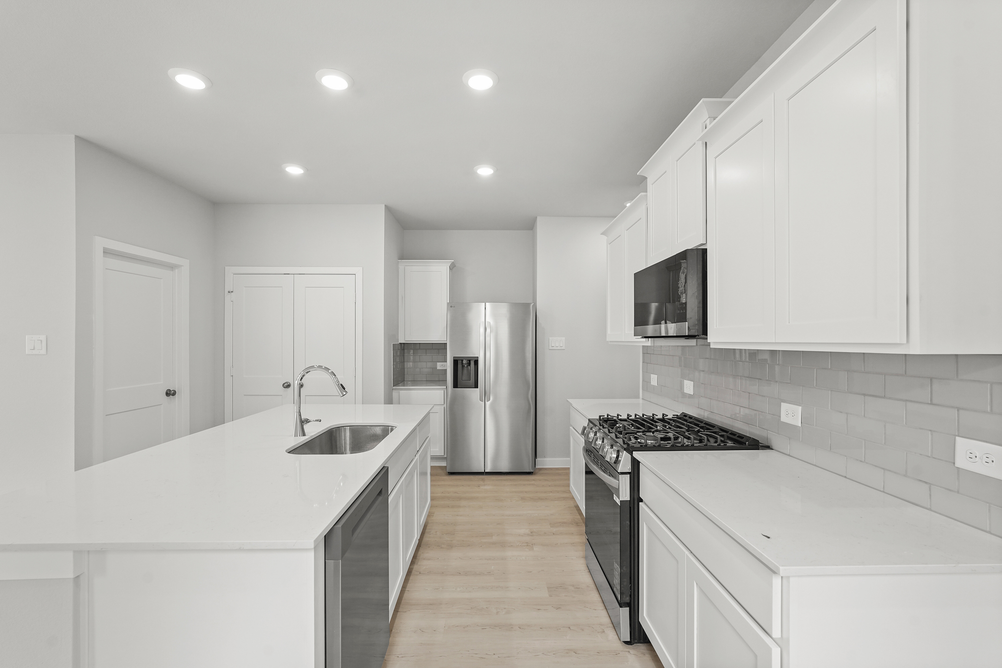 A kitchen with white cabinets.
